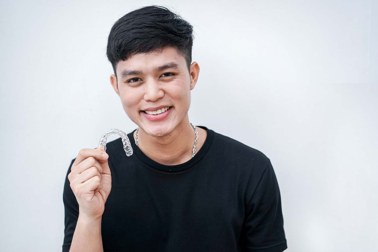 teen male holding aligners